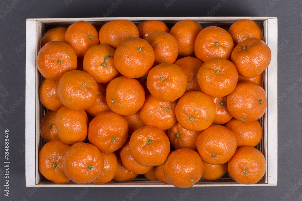 Fresh orange, tangerine fruit, mandarin pattern background in a wooden box, top view