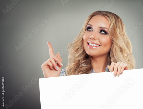Cute Young Woman Pointing her Finger Up and Holding White Paper Background