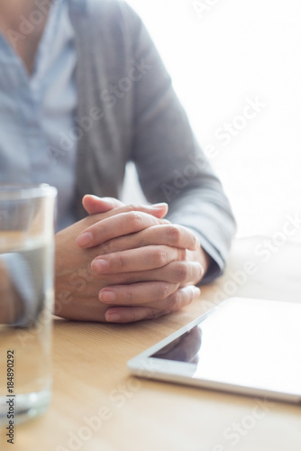 Closeup of Woman at Table with Water and Tablet photo