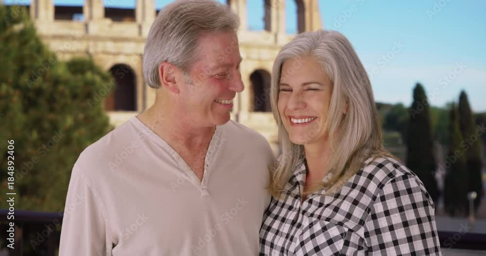 Happy mature Caucasian couple smile happily in front of Colosseum in Rome Happy mature Caucasian couple smile happily in front of Colosseum in Rome