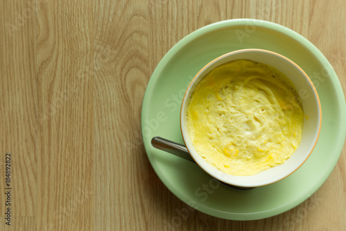 Steamed eggs in a bowl on wooden floor