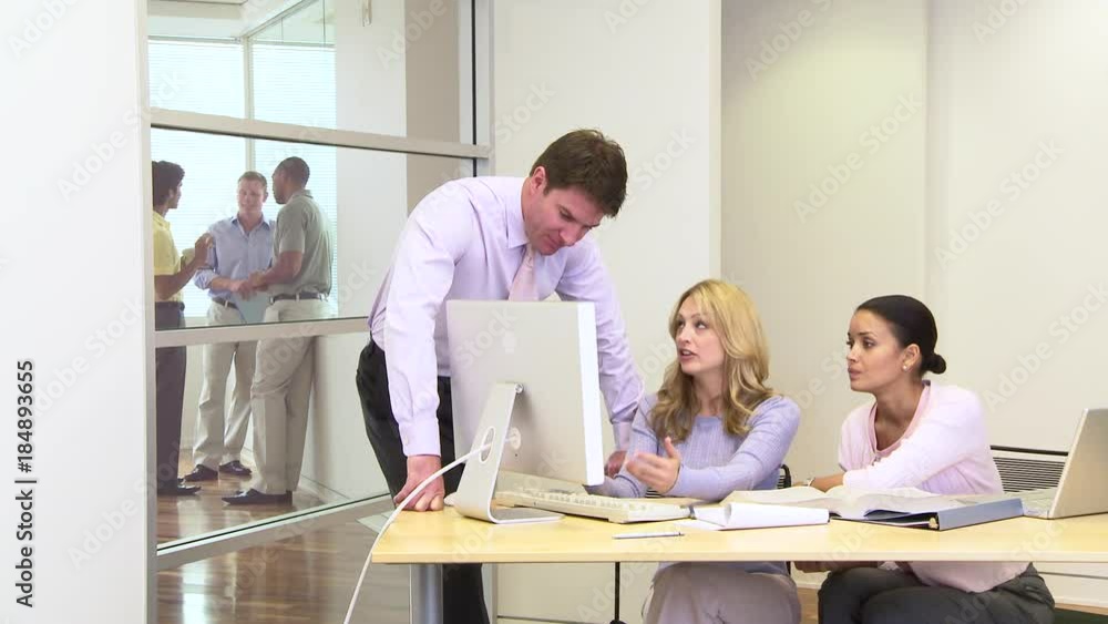 Group of coworkers at desk in busy office Group of coworkers at desk in busy office