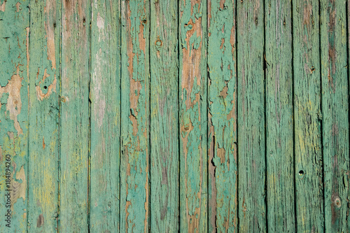Aged board of wood with weathered paint blistering off giving brown wooden texture background