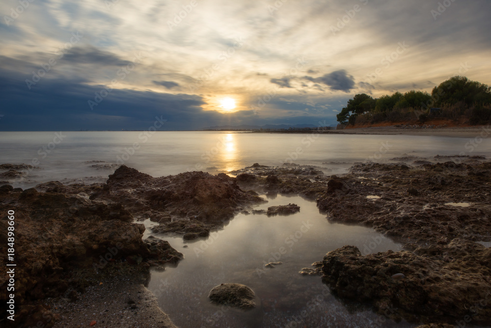 The calm sea in a very cloudy sunset The calm sea in a very cloudy sunset