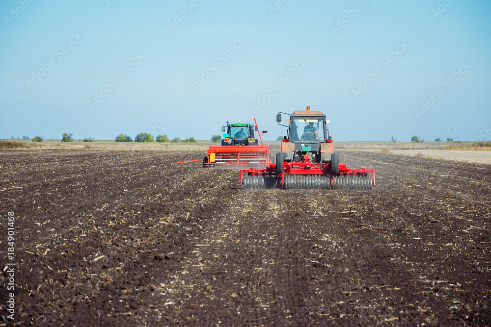 Obraz premium Tractor with a roller on the field at spring