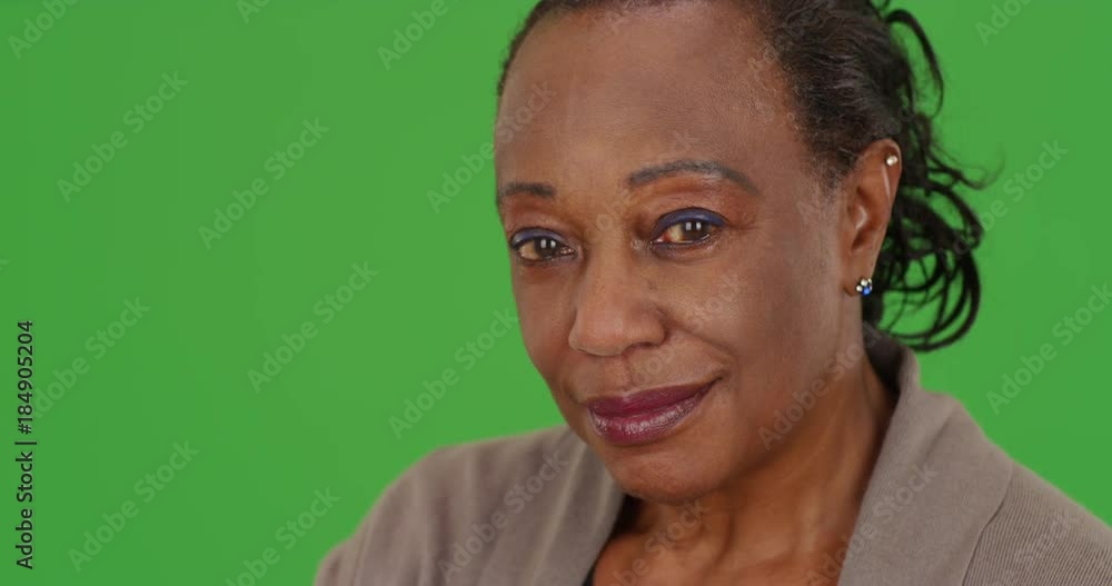 Close-up of a smiling elderly African American woman at work on green screen. On green screen to be keyed or composited. Close-up of a smiling elderly African American woman at work on green screen. On green screen to be keyed or composited.