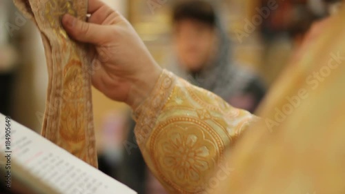 Holy Father blessing and crossing parishioners at religious service in church photo