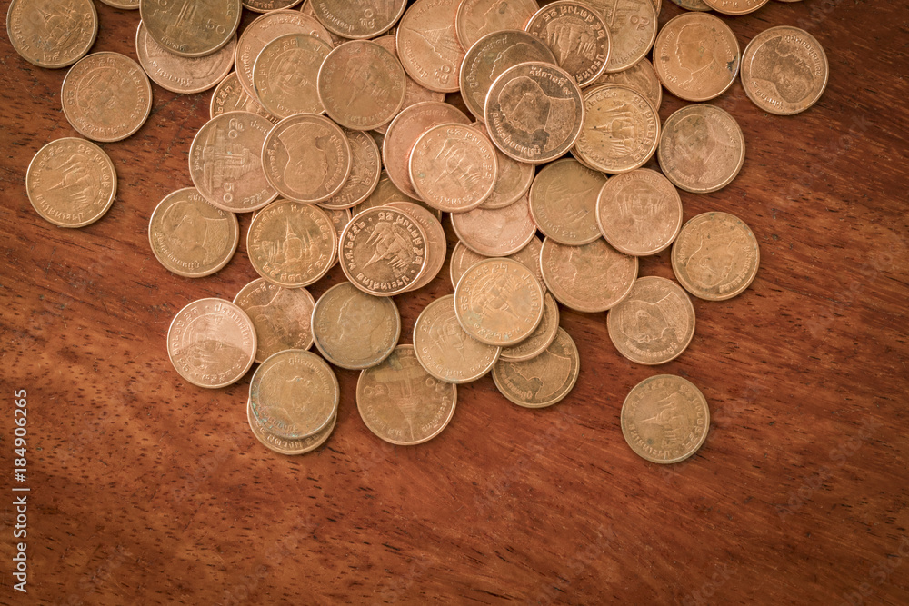 pile of Thai coins less worth lay on wooden table pile of Thai coins less worth lay on wooden table