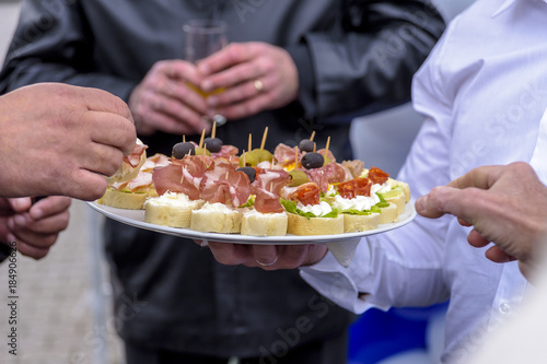 People eat canap  s served on a plate