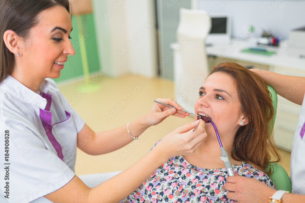 Beautiful woman patient having dental treatment at dentist's office. Woman visiting her dentist. Beautiful woman patient having dental treatment at dentist's office. Woman visiting her dentist.