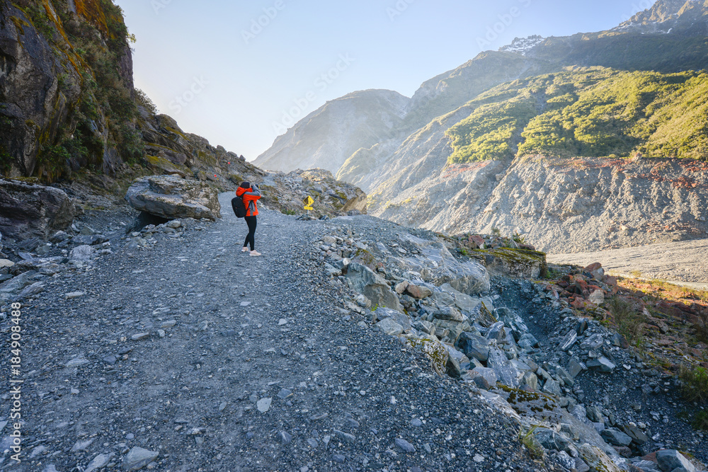 Woman tourist trekking to the Fox Glacier in New Zealand