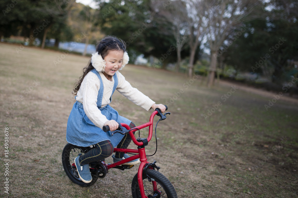 赤い自転車で遊ぶ女の子
