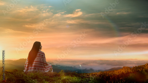 Fotografie Young asian woman sitting alone outdoor with wild forest mountains on background