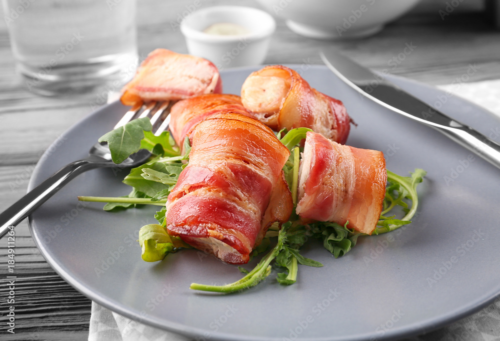 Plate with bacon wrapped chicken nuggets on table, closeup Plate with bacon wrapped chicken nuggets on table, closeup