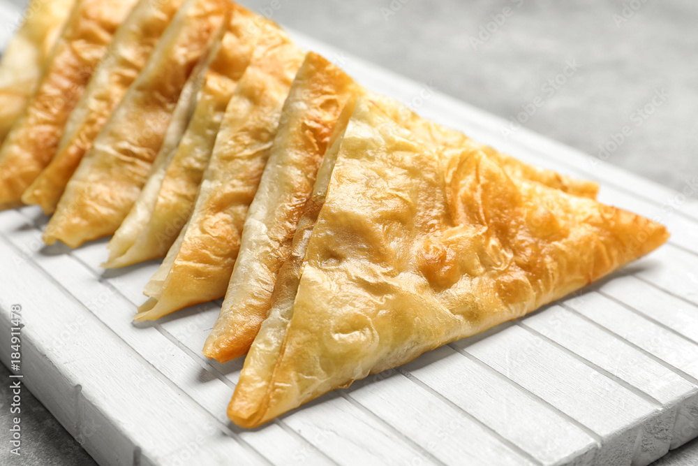 White wooden board with delicious samosas, closeup White wooden board with delicious samosas, closeup
