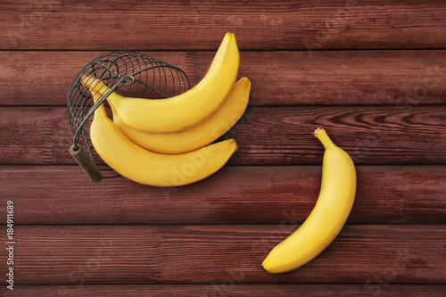 Tasty ripe bananas on color wooden background