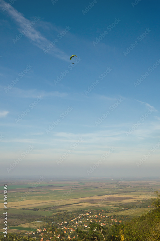 Paragliding above the suburb of town in the valley