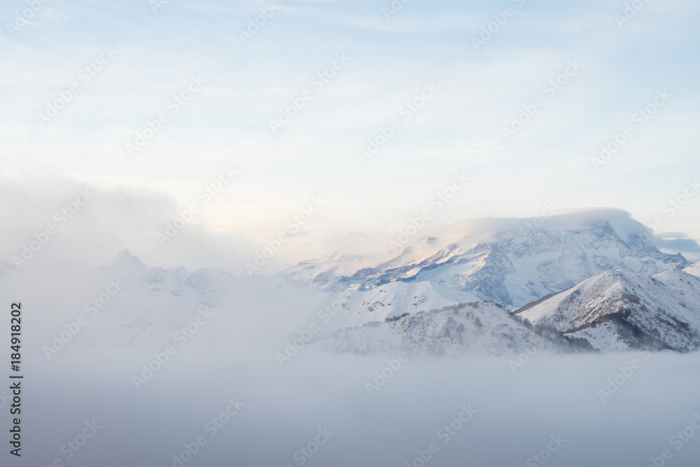 Winter panorama of the Italian Alps: Monte Rosa massif seen from the Biella pre-Alps. At sunset the fog rises from the valley bottom.