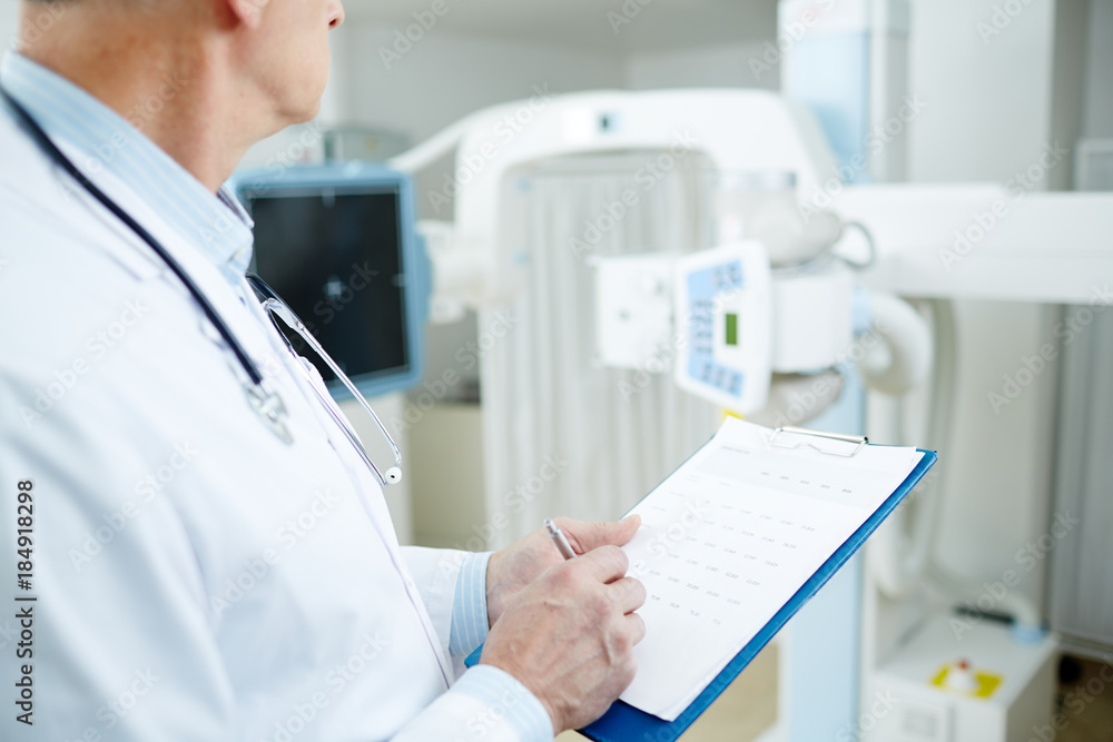 Modern clinician applying medical form after examination of patient Modern clinician applying medical form after examination of patient