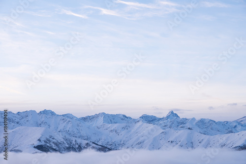 Winter panorama of Italian Alps with snow and fog