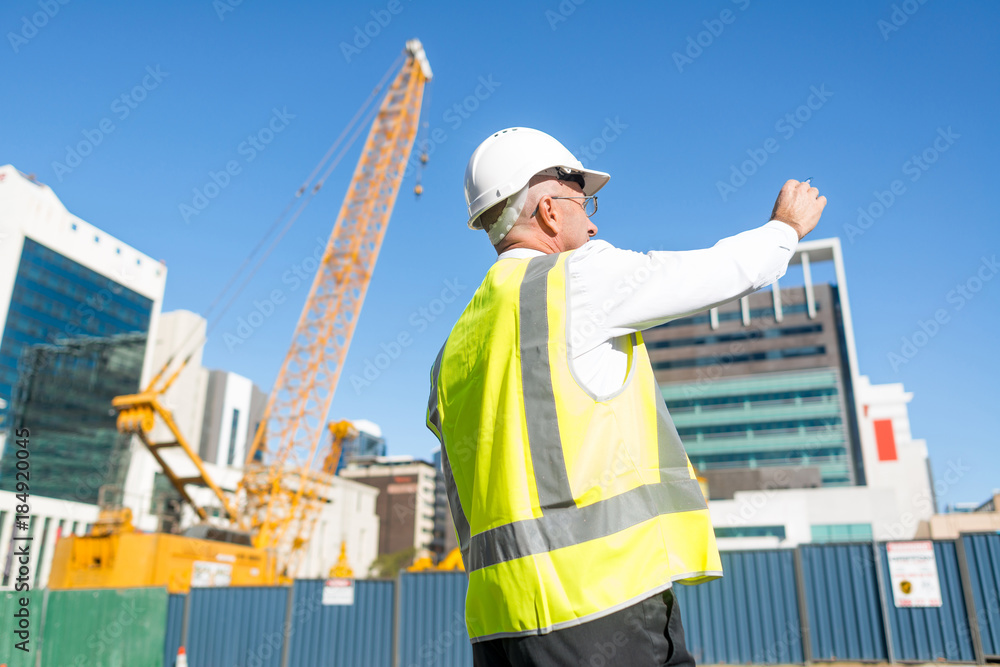 Senior foreman in glasses doing his job at building area on sunny day Senior foreman in glasses doing his job at building area on sunny day