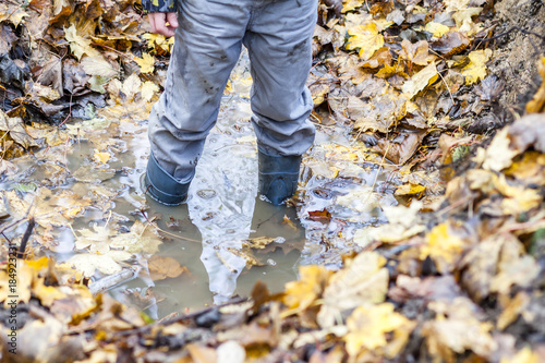 Little boy with wellys in the puddle