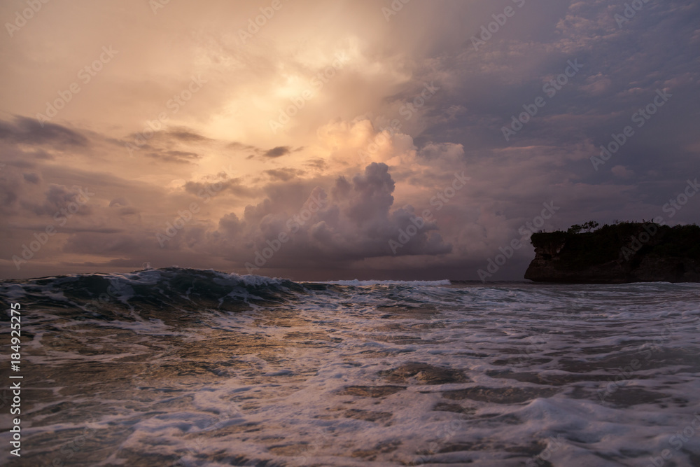 Beautiful sea wave and sky at sunset time. Landscape of sea with cliffs on background. Panorama of beautiful sunset on the ocean. Sea foam on surface of water.