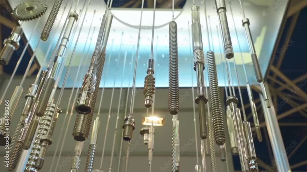Various bolts, metal studs with thread and other metal parts from the equipment are hang and shine in the light. Shot in motion Various bolts, metal studs with thread and other metal parts from the equipment are hang and shine in the light. Shot in motion