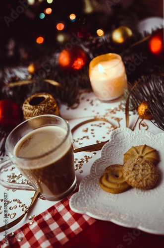 Cup of coffee, candle and cookies on table with winter and christmas decorations.  © veradimov