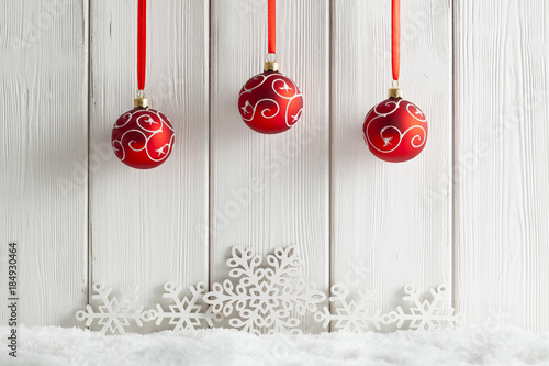 Christmas background - snowflakes and baubles on snow and wooden wall