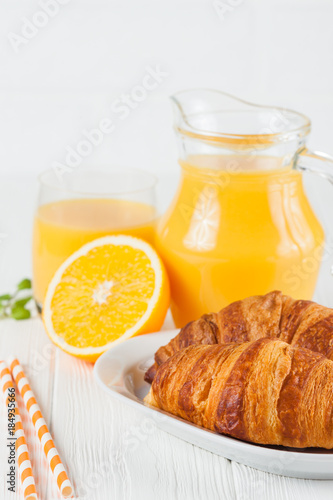 Freshly baked croissant  orange juice  fresh fruits  jam on white wooden background. French breakfast. Fresh pastries for morning. Delicious dessert. Closeup photography. Vertical banner