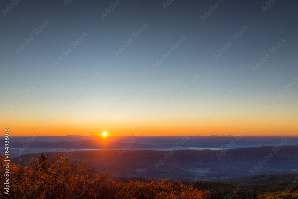 Fototapeta premium Morning dark sunrise with sky and golden yellow orange autumn foliage in Dolly Sods, Bear Rocks, West Virginia with overlook of mountain valley