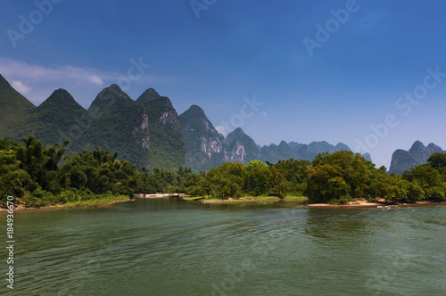 View of the Li River with the tall limestone peaks on the background near Yangshuo, China, Asia; Concept for travel in China
