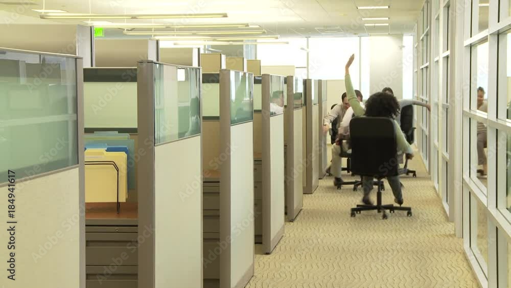 Young business colleagues racing with chairs in office Young business colleagues racing with chairs in office