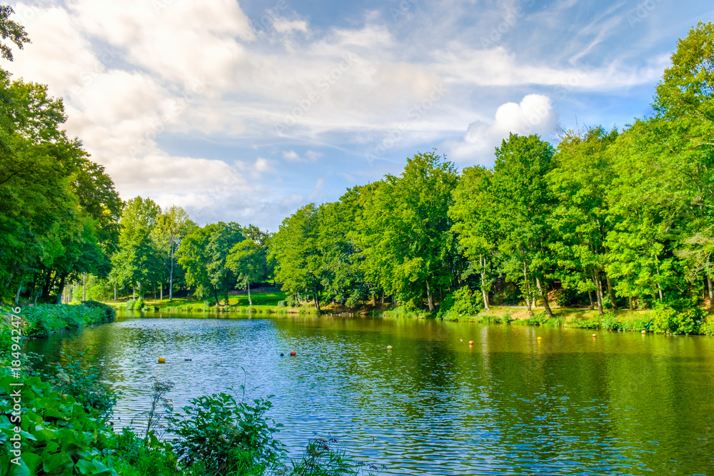 St-Fraimbault's pond in the Orne surrounded by a luxuriant vegetation in summer, Normandy France St-Fraimbault's pond in the Orne surrounded by a luxuriant vegetation in summer, Normandy France