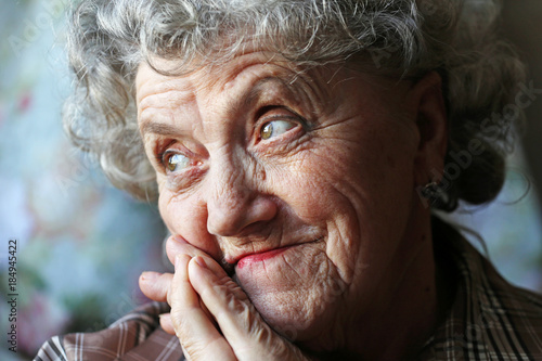 Thoughtful and looking elderly woman face