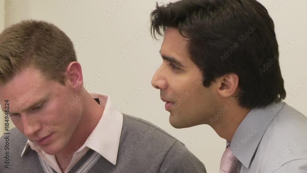 Close up of two coworkers talking to group off screen Close up of two coworkers talking to group off screen