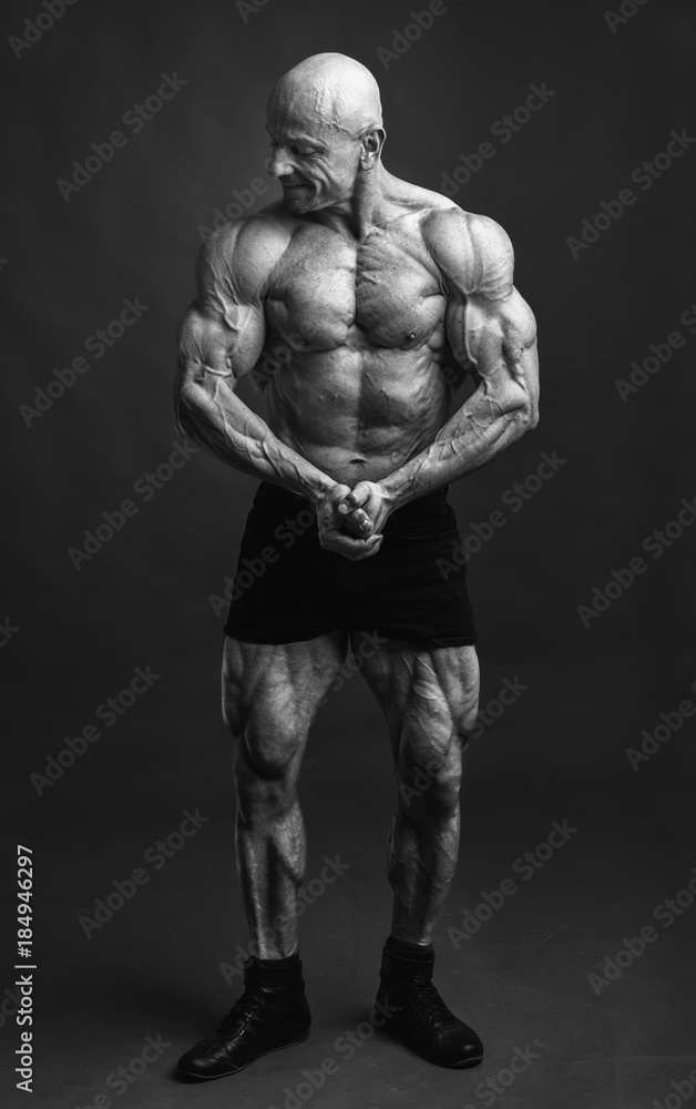 Athlete in front pose. Bodybuilder showing muscles and motivating to training. Athlete in front pose. Bodybuilder showing muscles and motivating to training.