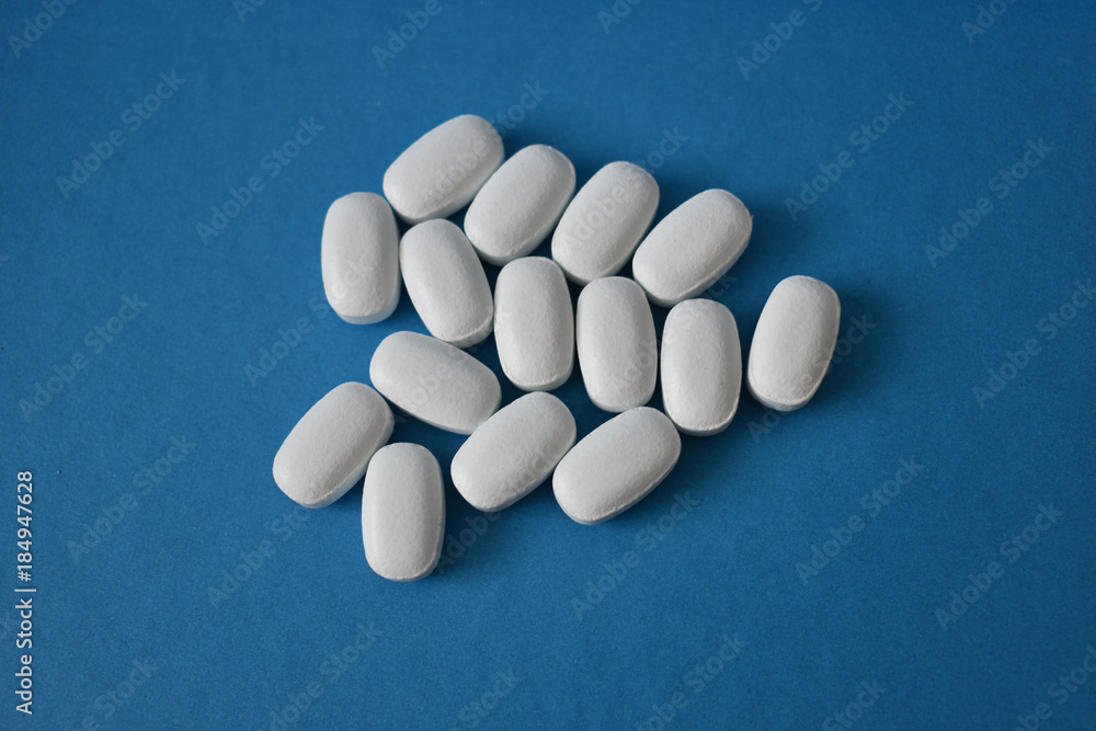 White pills on a blue background White pills on a blue background
