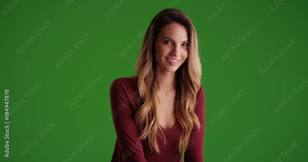 Female millennial sitting in contrasty lighting on green screen. On green screen to be keyed or composited. Female millennial sitting in contrasty lighting on green screen. On green screen to be keyed or composited.
