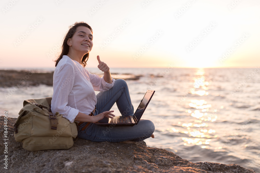 Fototapeta premium freelancer girl on the beach with her thumb up