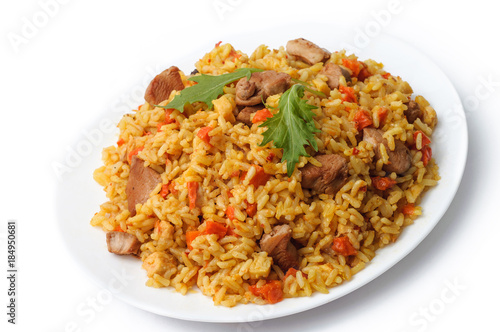 rice pilaf with meat and vegetables top view on a plate. Isolated on white.