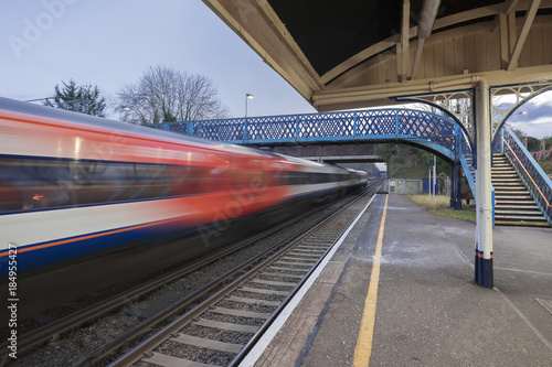 Fast express train passing through a Victorian UK station in southern England