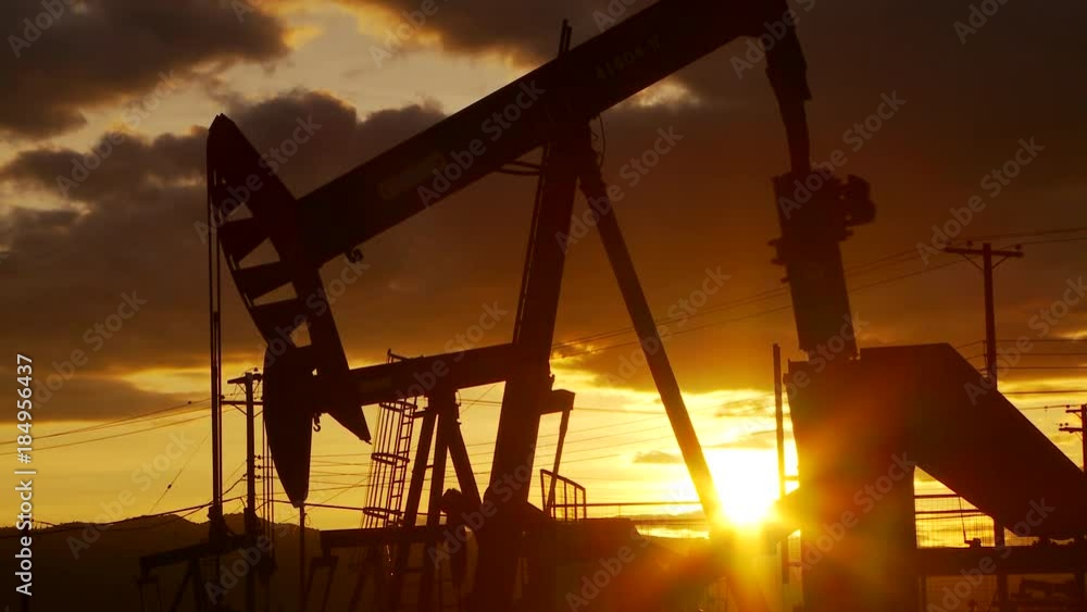 Oil well piston pumps at sunset Oil well piston pumps at sunset
