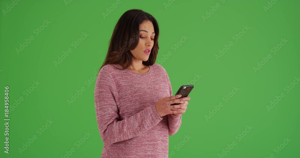 Attractive Latina female messaging on cell phone on green screen. On green screen to be keyed or composited. Attractive Latina female messaging on cell phone on green screen. On green screen to be keyed or composited.