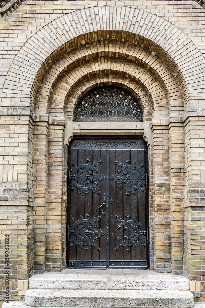 Big double wooden door at Synagogue with arch, stairs and brick wall in Novi Sad, Serbia Big double wooden door at Synagogue with arch, stairs and brick wall in Novi Sad, Serbia