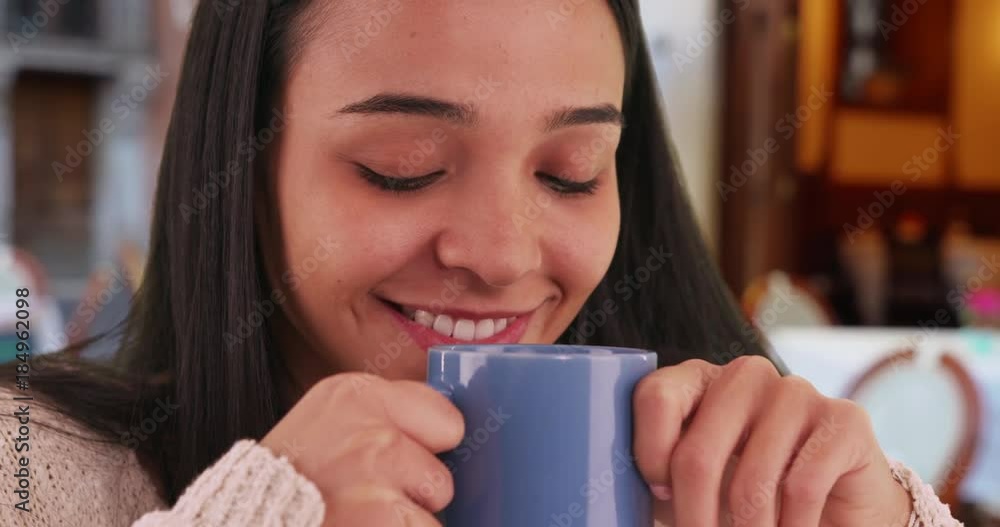 Smiling Latina enjoys the aroma of her coffee at a local cafe. Happy Hispanic woman enjoys a hot beverage at an urban cafe. 4k Smiling Latina enjoys the aroma of her coffee at a local cafe. Happy Hispanic woman enjoys a hot beverage at an urban cafe. 4k