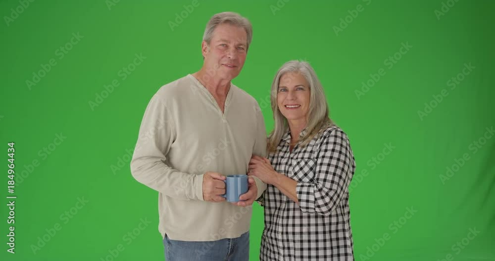 Lovely senior couple smiling at camera on green screen Lovely senior couple smiling at camera on green screen