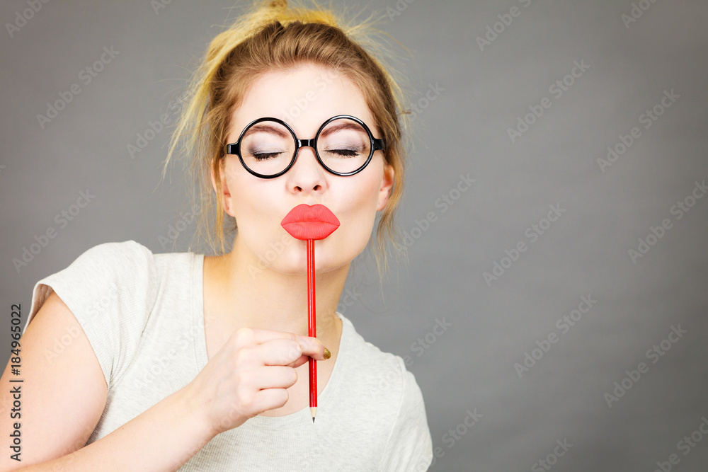 Happy woman holding fake lips on stick