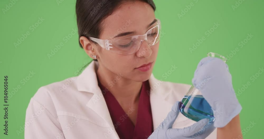 Young female scientist chemist or medical researcher looking at blood samples in test tubes and beakers on greenscreen for compositing. Hispanic woman student working on pharmaceutical research. 4k Young female scientist chemist or medical researcher looking at blood samples in test tubes and beakers on greenscreen for compositing. Hispanic woman student working on pharmaceutical research. 4k